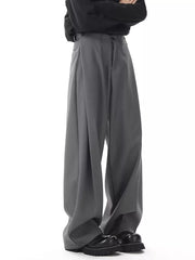 Men's dark gray flowy wide-leg sweatpants with pleats and button closure.