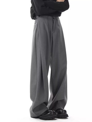 Men's dark gray flowy wide-leg sweatpants with pleats and button closure.