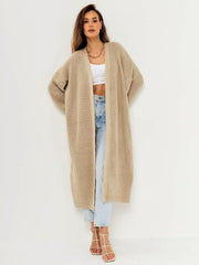 Oversized tan ribbed knit maxi cardigan with a relaxed fit and open front, styled with jeans.