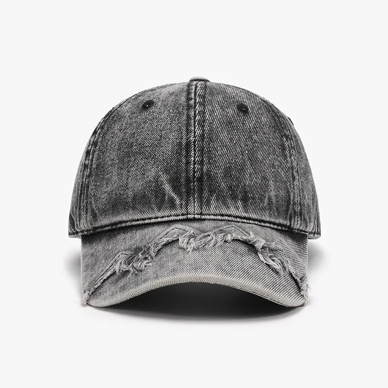 Acid wash distressed baseball cap in black denim with frayed brim detail.