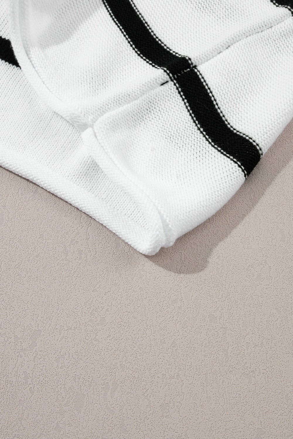 White knit shell top with black horizontal stripes and a textured knit detail.