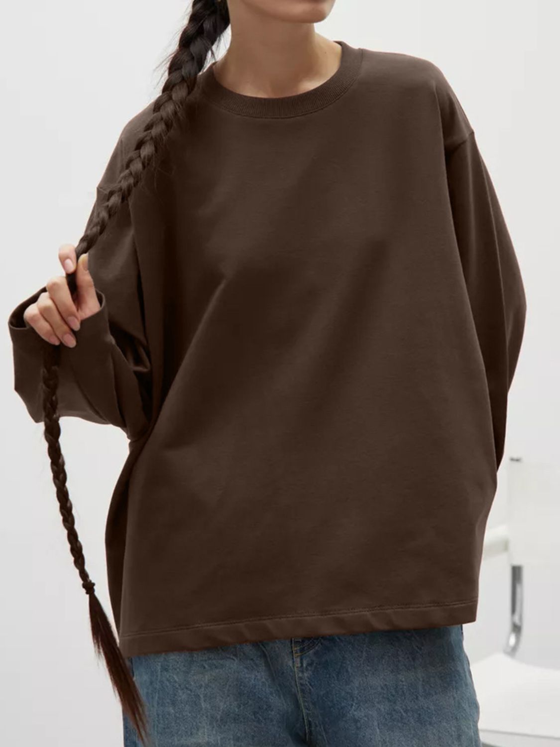 Oversized crewneck sweatshirt in dark brown with voluminous sleeves and a relaxed fit.