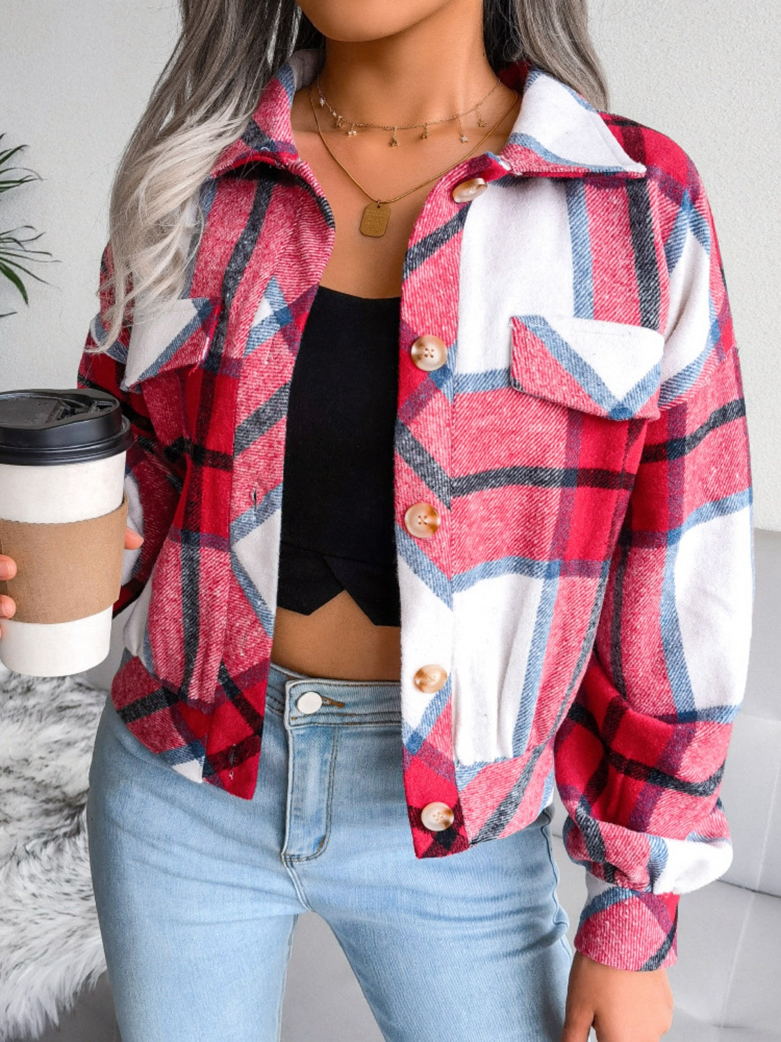 Oversized red plaid shacket with patch pockets and button front, worn with jeans.