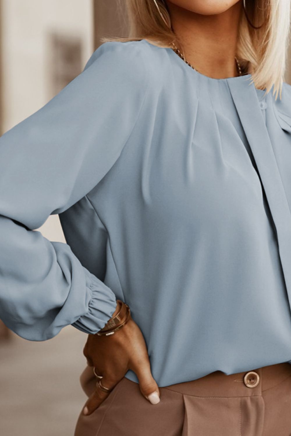 Misty Blue pleated yoke blouse with button detail and cuffed sleeves.