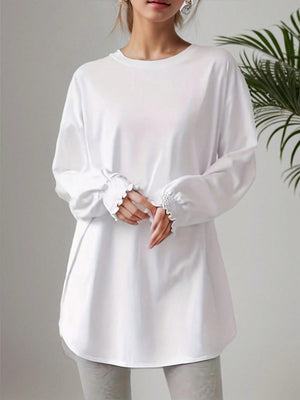 White oversized tunic top with ruffled cuffs and crew neck.