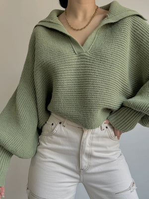 Army green knit sweater with wide collar and balloon sleeves, styled with white jeans.