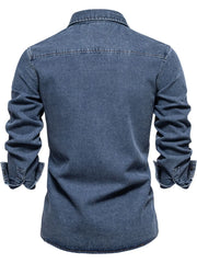 Light blue denim utility shirt with buttoned cuffs and a zip pocket detail.