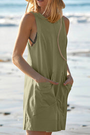 Relaxed fit linen romper in Matcha Green with side pockets and a straw hat.
