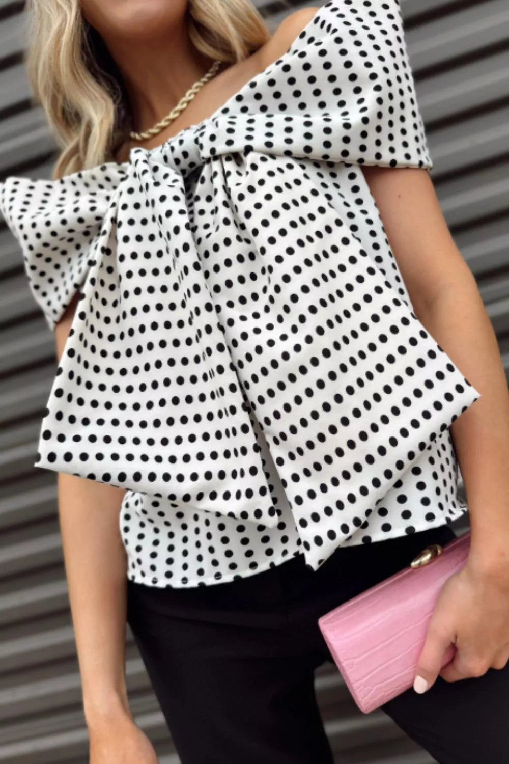 Chic off-shoulder polka dot blouse with large bow detail in white and black polyester.