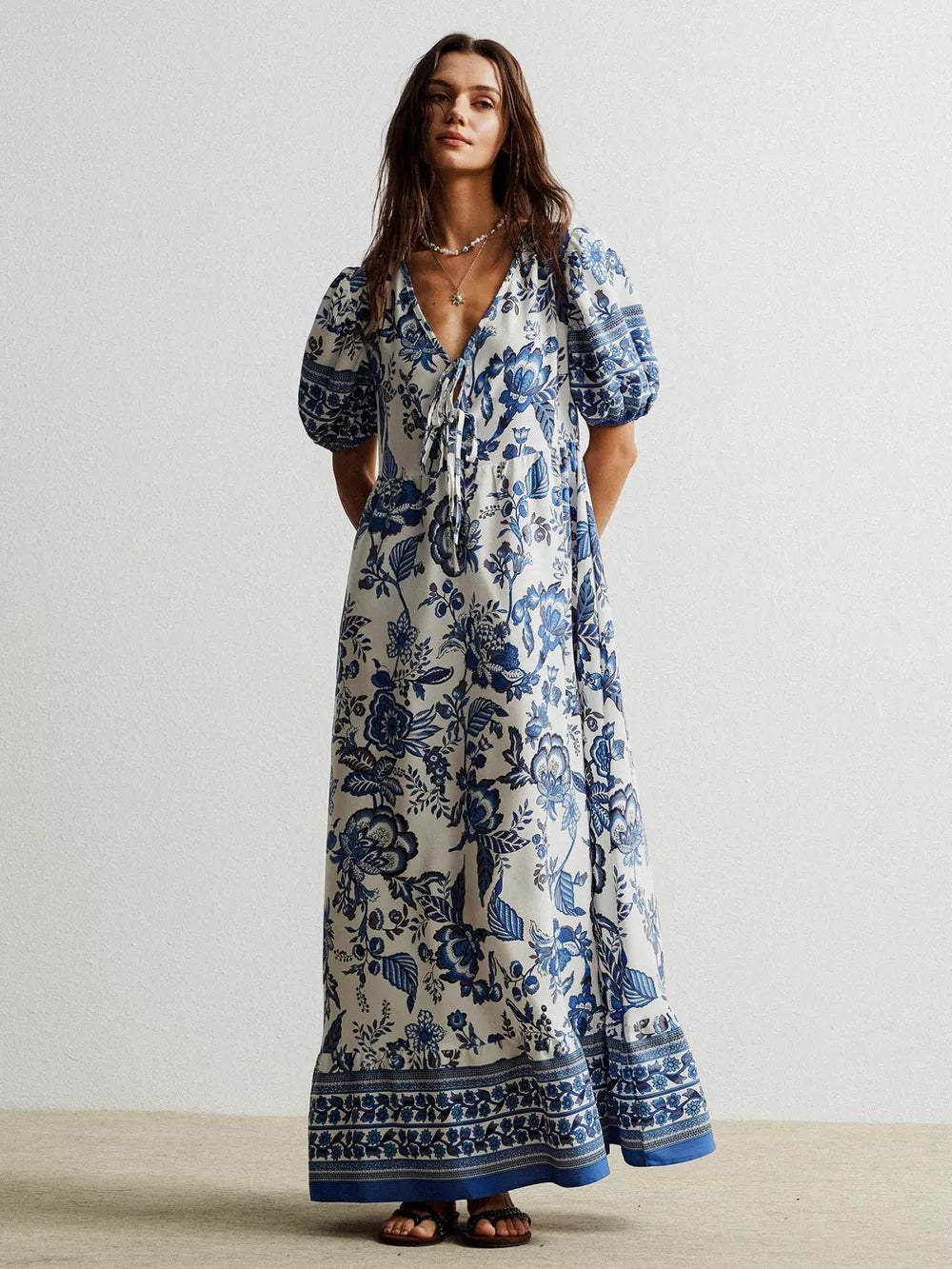 Charming floral maxi dress with tie-neck, puff sleeves, and ruffled hem.