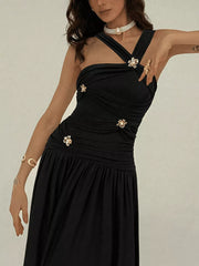 Black ruched sleeveless maxi dress with floral embellishments and a pull-over closure.