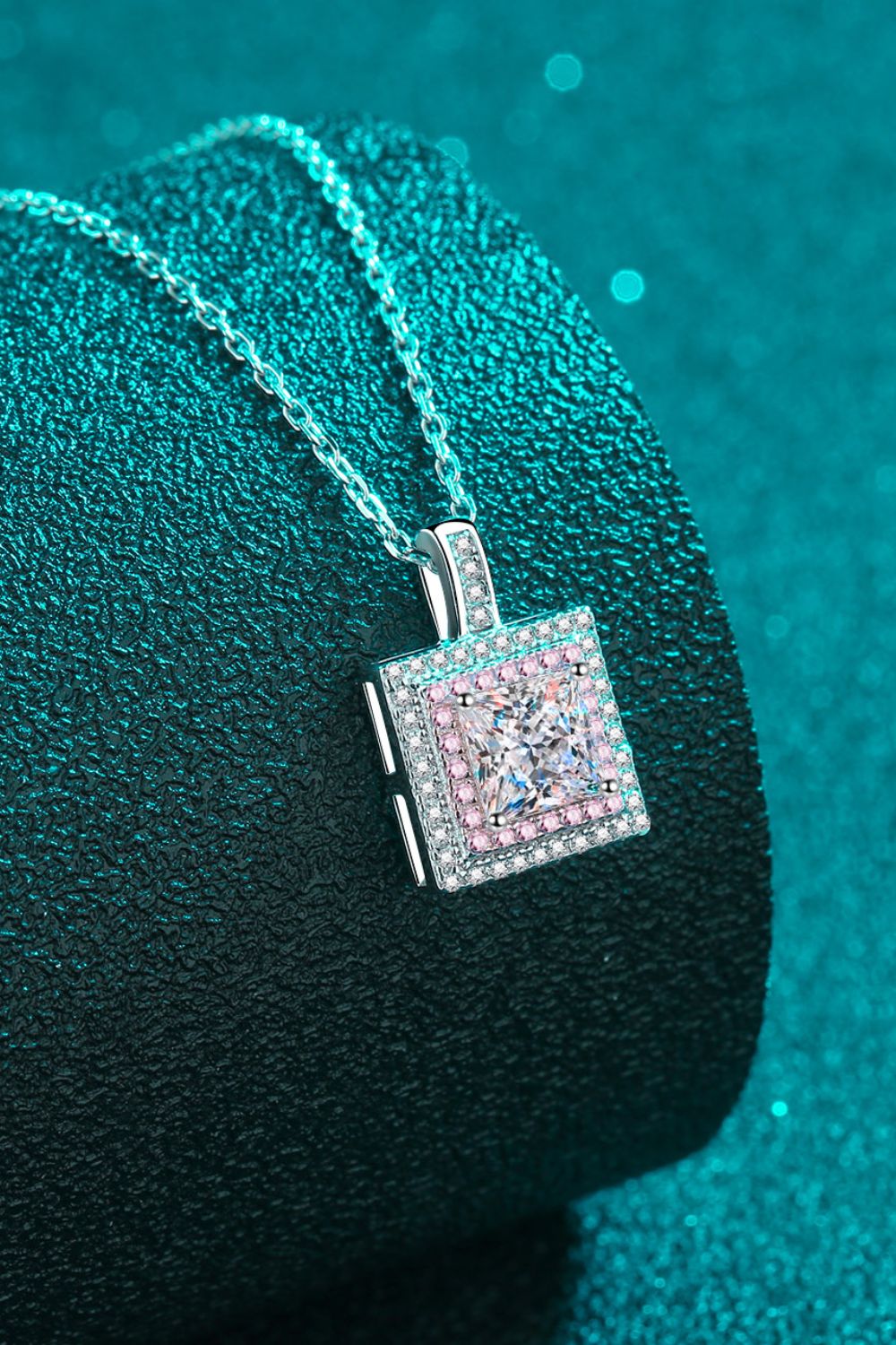 Silver moissanite halo pendant necklace with square-cut center stone and pink accent stones.