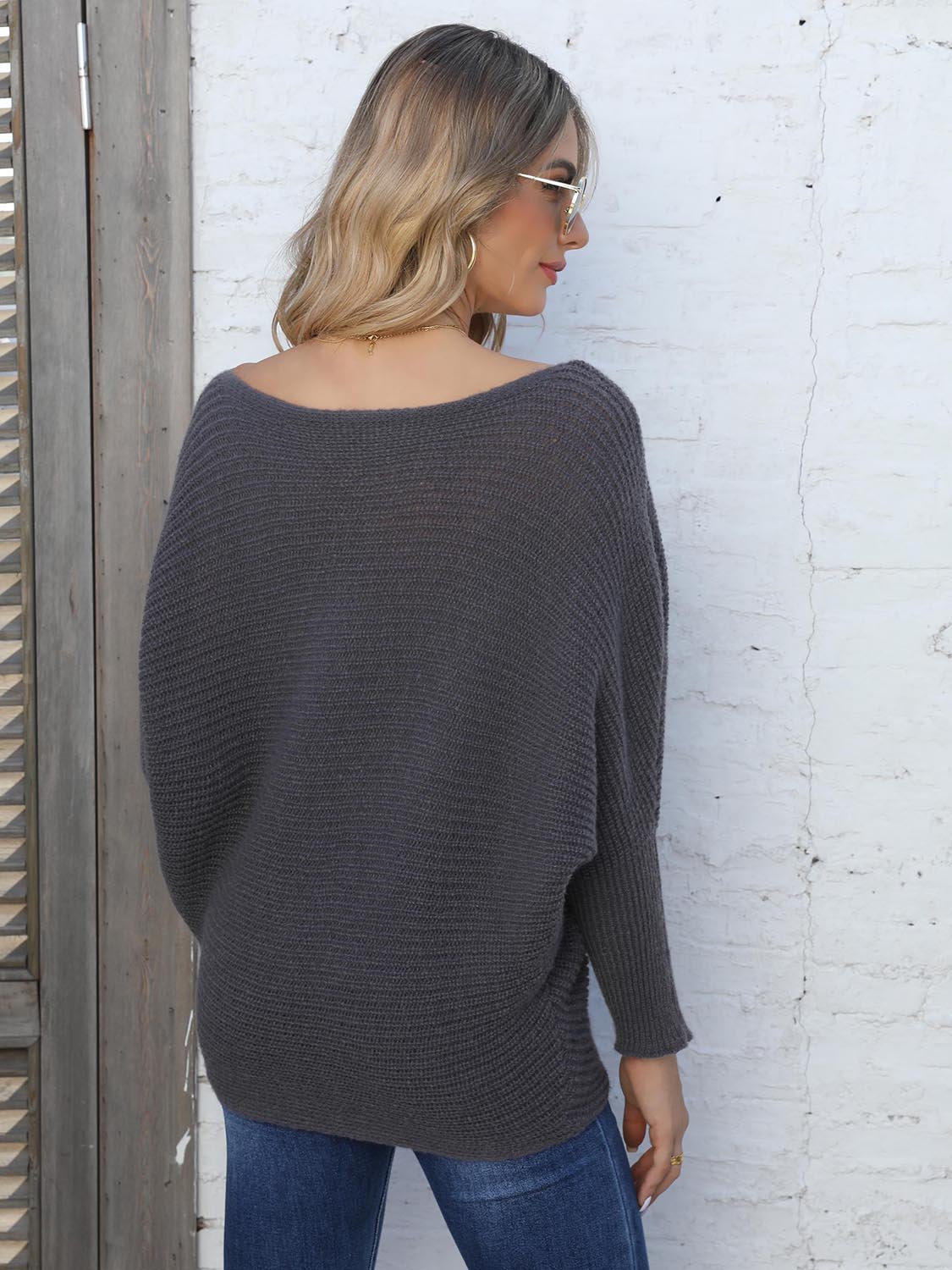 Off-the-shoulder ribbed dolman knit sweater in dark gray with long sleeves.