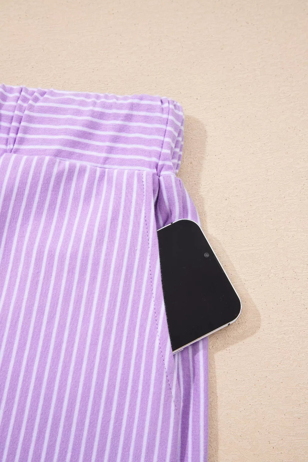 Purple striped cotton shorts with a phone in the pocket.