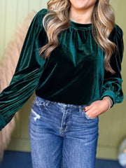 Dark green velvet blouse with ruched neckline and puff sleeves.
