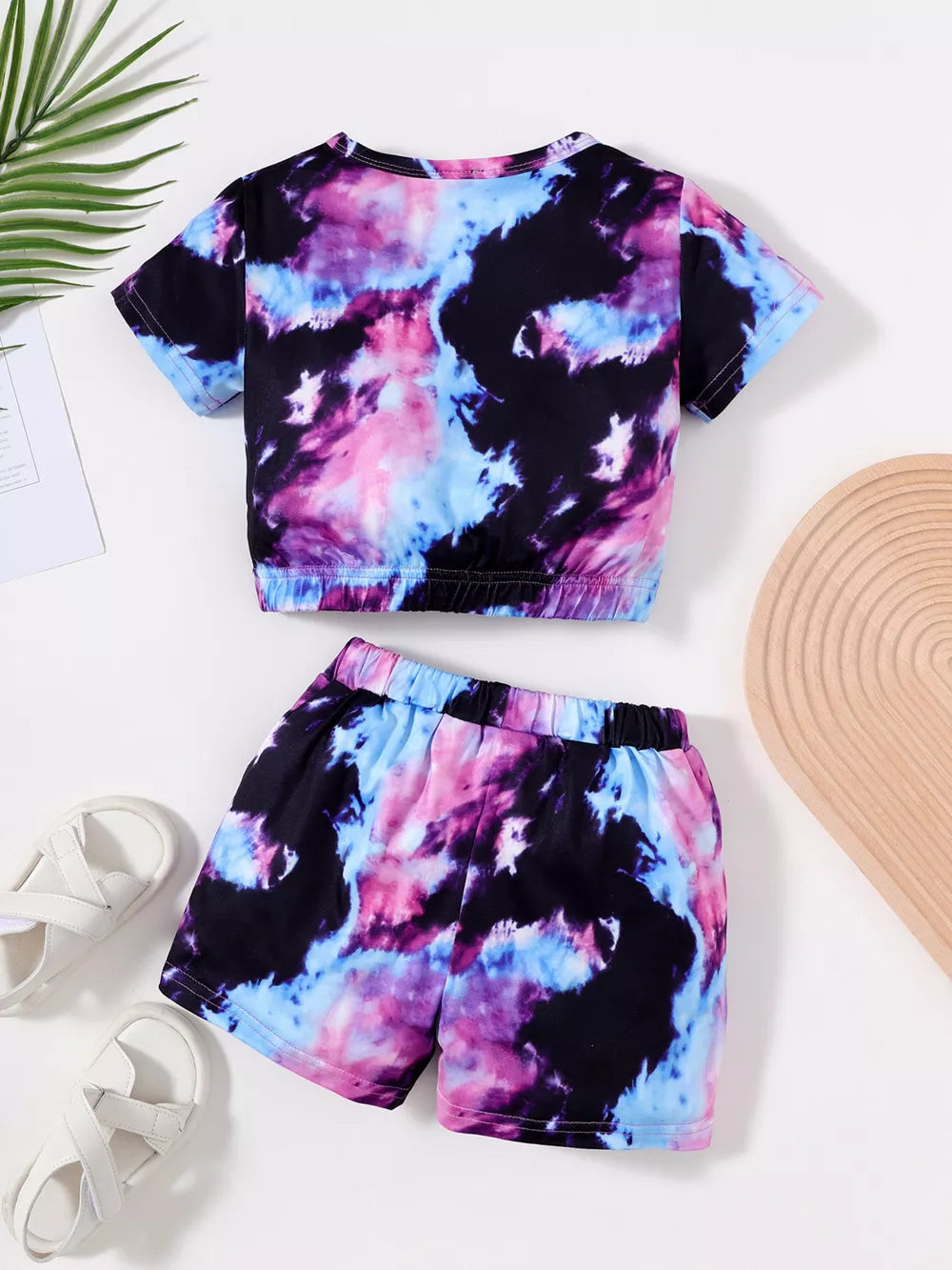Girls tie-dye two-piece set with short sleeve top and shorts in pink, blue, and purple.