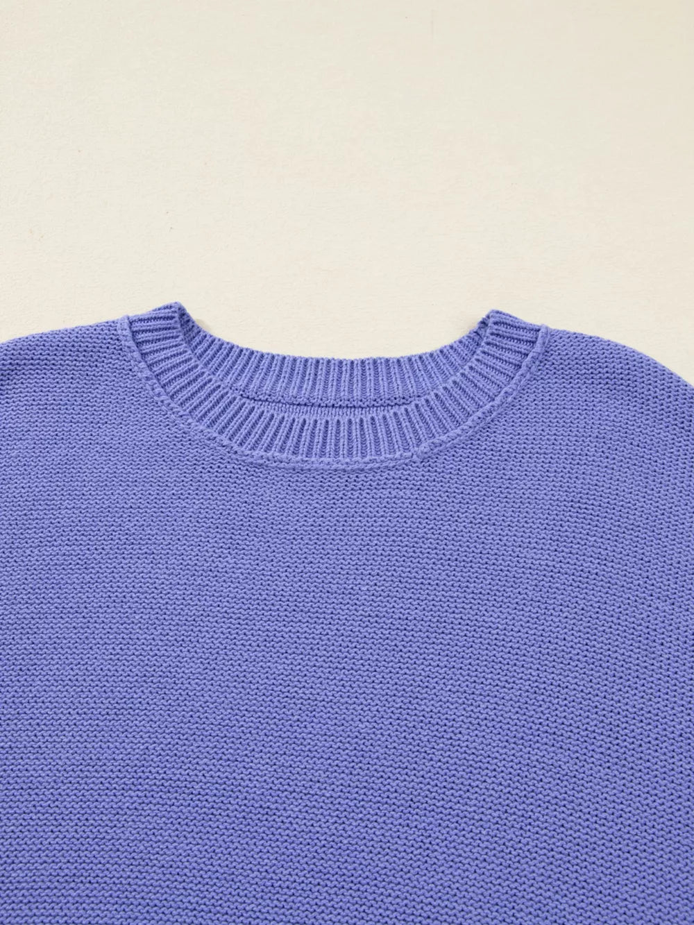 Purple knit sweater with crew neck and ribbed details.