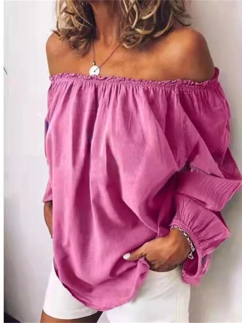 Pink off-the-shoulder maternity shirt with gathered neckline and frill detail on sleeves.