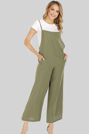 Sage culotte overalls with slender straps and wide legs, styled with a white tee.
