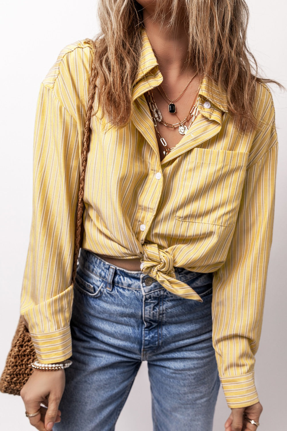 Oversized pastel yellow stripe oxford shirt with button front and knotted hem.