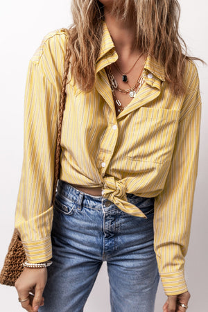 Oversized pastel yellow stripe oxford shirt with button front and knotted hem.