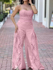 Pink strapless openwork top and wide-leg pants set with intricate cut-out details.