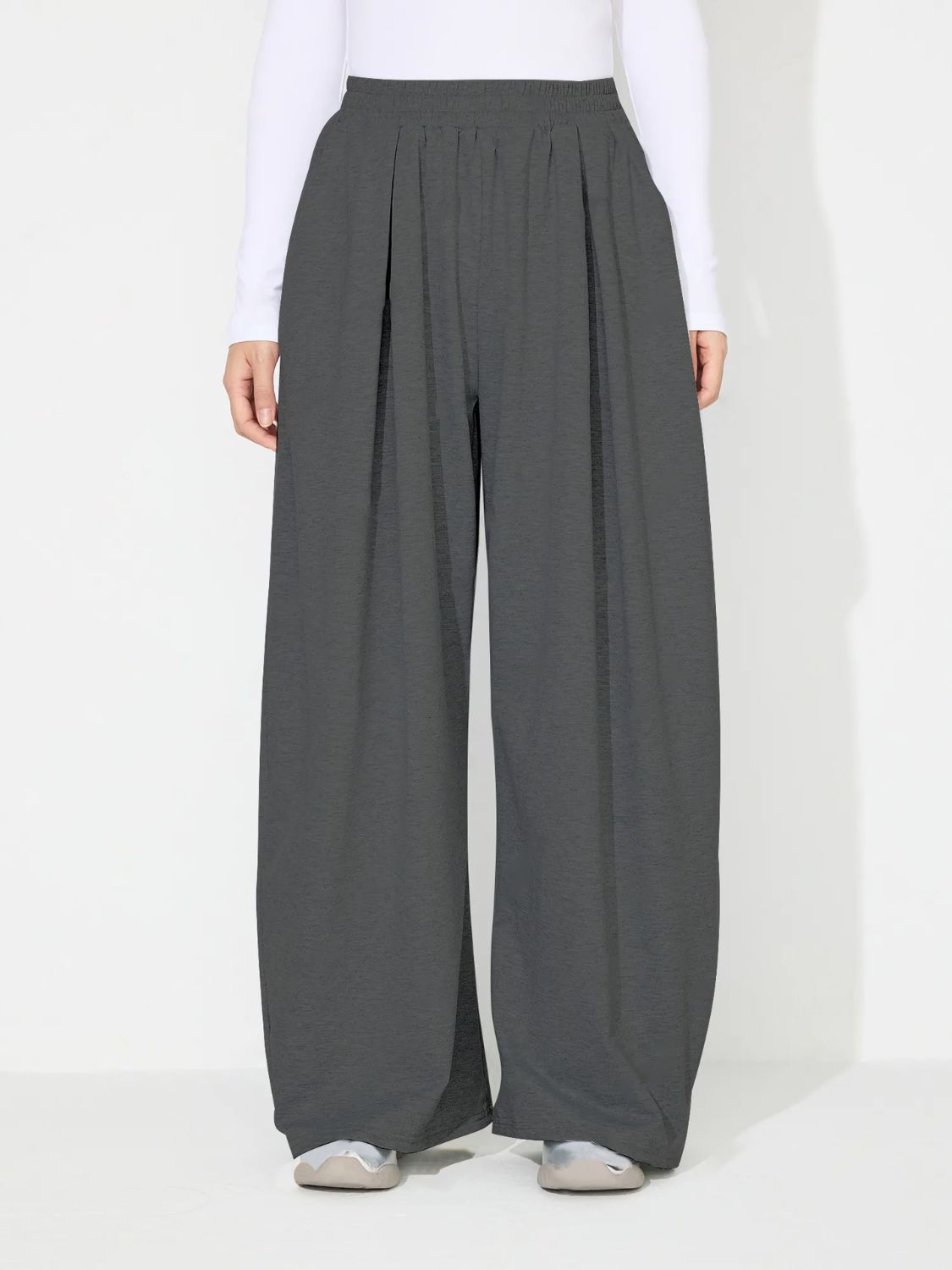 Dark gray pleated drape palazzo trousers with a wide leg and elastic waistband.
