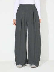Dark gray pleated drape palazzo trousers with a wide leg and elastic waistband.