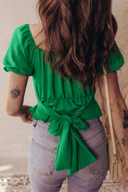 Green ruched peplum shirt with puff sleeves and a tie-back detail.