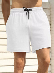 White men's drawstring chino shorts with textured fabric and pockets.