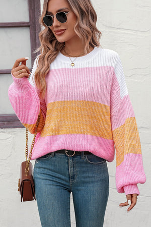 Striped acrylic sweater with balloon sleeves in pink, white, and yellow, featuring a ribbed knit texture.
