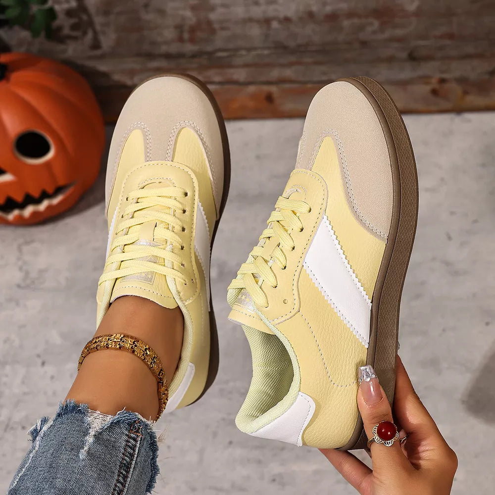 Yellow suede and patent leather lace-up sneakers with white accents.