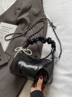 Black ruched mini crossbody bag with pearl pendant and chain strap