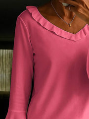 Fuchsia pink polyester blouse with ruffled V-neck and bell sleeves.