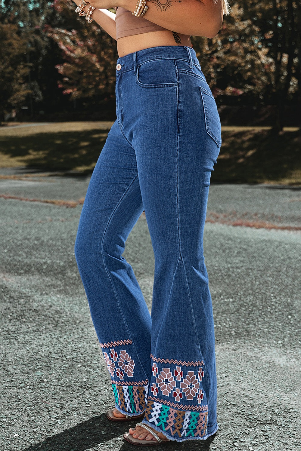 Medium wash denim flare jeans with embroidered hem detail