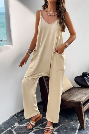Light yellow relaxed drape pocket jumpsuit with V-neck and spaghetti straps.