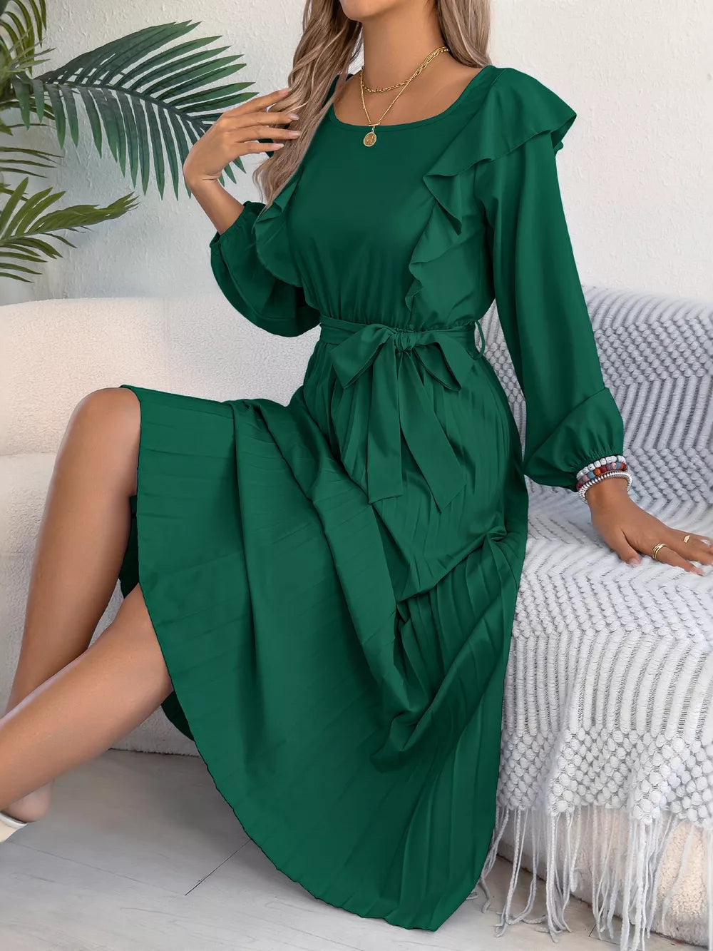 Green ruffled A-line midi dress with tie waist and pleated skirt.