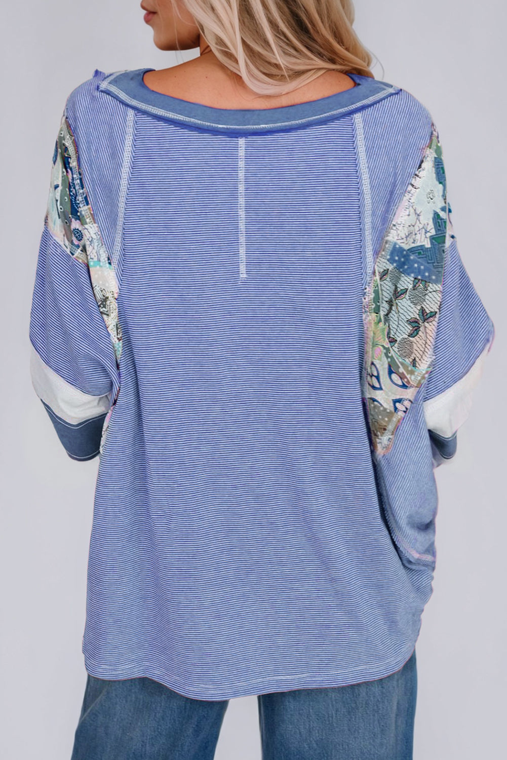 Patchwork stripe raglan tee in dusty blue with artistic sleeve details and a relaxed fit.