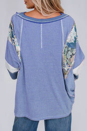 Patchwork stripe raglan tee in dusty blue with artistic sleeve details and a relaxed fit.