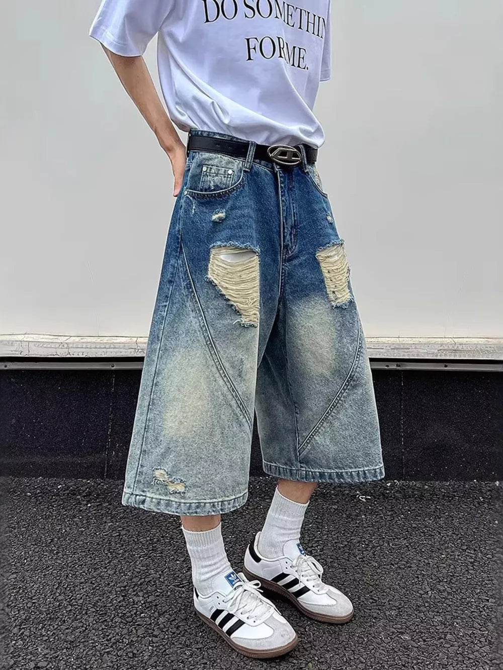 Distressed wide-leg denim shorts in blue with ripped details and a relaxed fit.