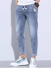 Light blue washed skinny jeans with adjustable drawstring and cuffed ankles.