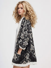 Geometric jacquard knit open cardigan in black with white and cream pattern, featuring pockets.