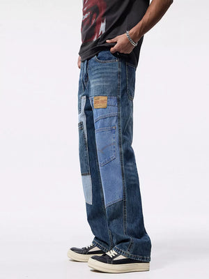 Relaxed fit patchwork jeans in blue denim with distressed details and a leather patch.