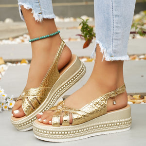 Gold crocodile-embossed platform sandals with crisscross straps and adjustable buckle.