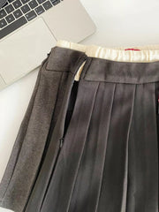 Chic drawstring pleated skirt in dark gray with a side zipper detail and cream ribbed waistband.