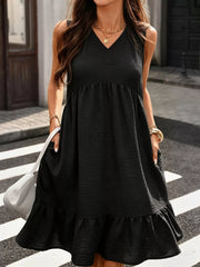Black V-neck sleeveless ruffle hem dress with textured fabric and pockets.