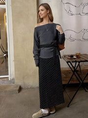Black polka dot maxi skirt with a belted waist, paired with a grey off-the-shoulder top.