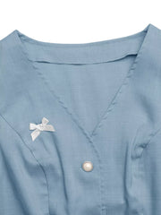 Blue buttoned vest with pearl button and polka dot bow detail