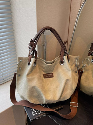 Khaki slouchy crossbody bag with adjustable strap and brown leather handles.
