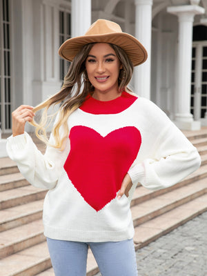 White acrylic sweater with a large red heart intarsia pattern and red neckline.